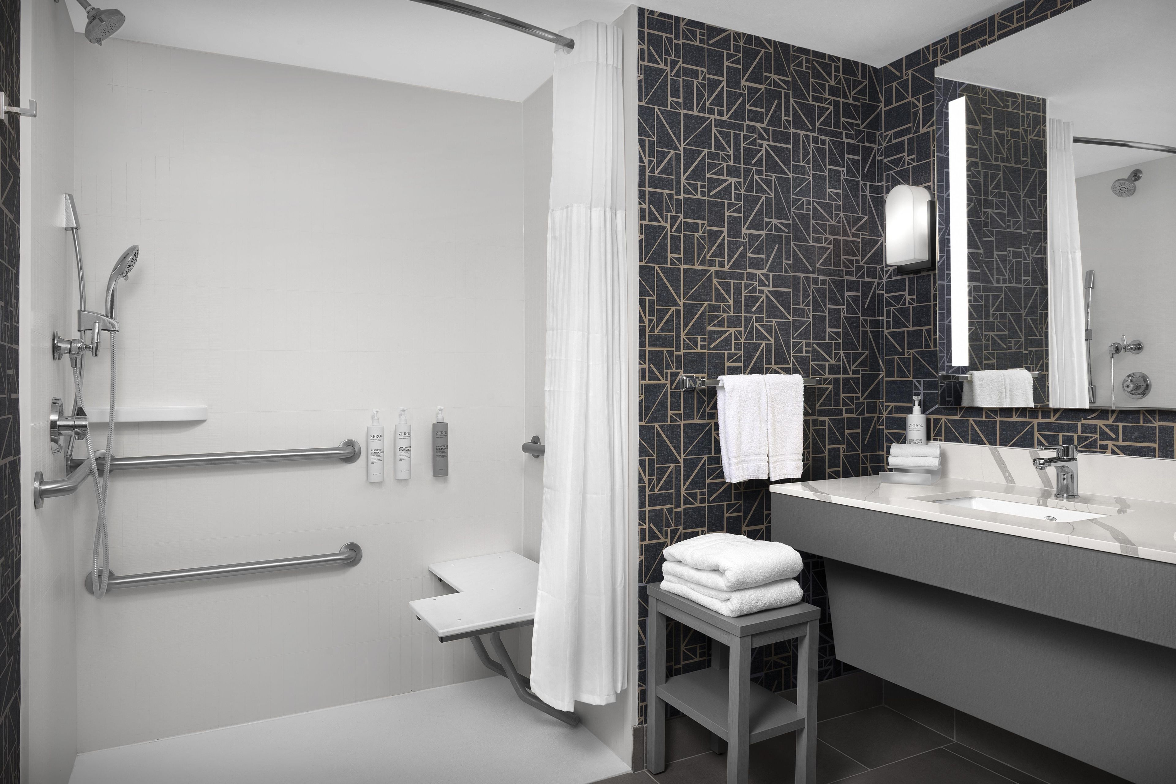A modern bathroom with a shower, toilet, and vanity.