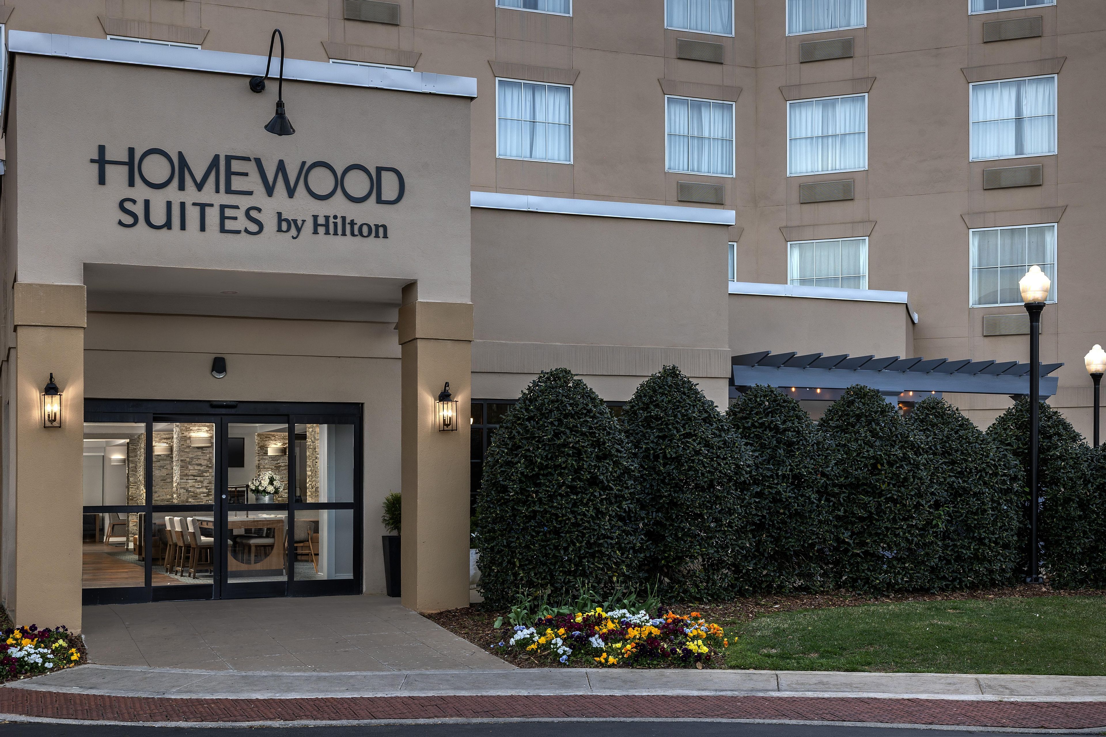 A hotel entrance with a sign reading 'HOMEWOOD SUITES by Hilton'.