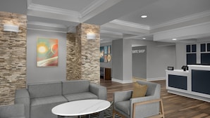 A modern lobby with a stone accent wall, a reception desk, and seating areas.