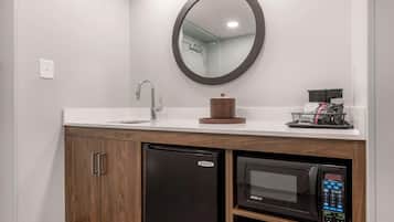 Une salle de bain moderne équipée d’un lavabo, d’un miroir, d’un lave-vaisselle et d’un four à micro-ondes intégrés.