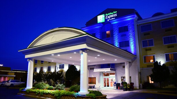 A Holiday Inn Express building with a covered entrance, a landscaped garden, and a parking area. - Holiday Inn Express Hotel & Suites Watertown-Thousand Island by IHG (Watertown)
