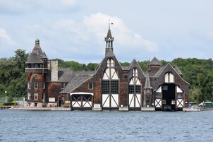 Un edificio histórico con una torre destacada, ventanas amplias y un muelle que se adentra en el agua.