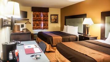 A hotel room with two beds, a desk with a coffee maker, a TV, and a microwave.