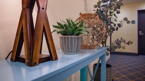 A table with a potted plant, a decorative wooden structure, and a woven basket. - Holiday Inn Lucedale by IHG (Lucedale)