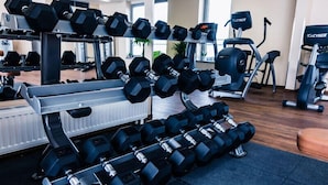A gym with multiple sets of dumbbells, exercise machines, and a mirrored wall. - Holiday Inn Lucedale by IHG (Lucedale)