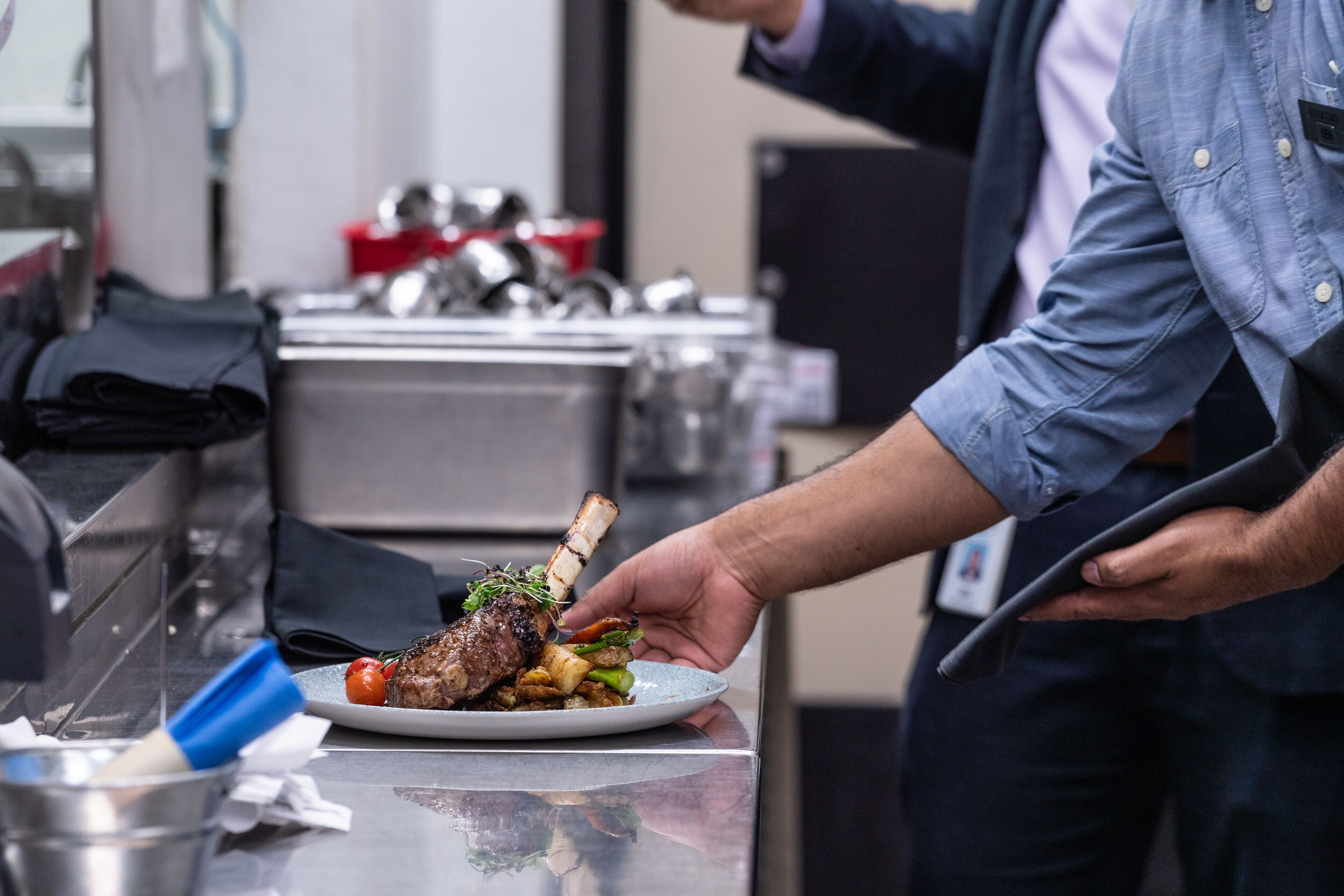 A chef serving a dish on a plate.