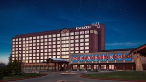 Un hôtel avec une grande enseigne indiquant « RIVER CREEK CASINO » et une façade de bâtiment moderne.
