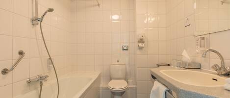 Un baño moderno con bañera, inodoro y lavamanos.