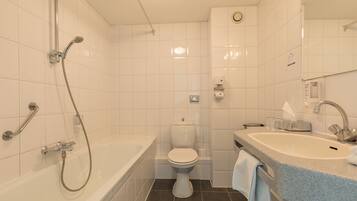 A bathroom with a bathtub, toilet, and sink.