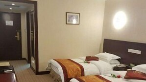 A hotel room with two beds, a wooden desk, and a framed picture on the wall. - Yunnan Aviation Sightseeing Hotel (Lijiang)