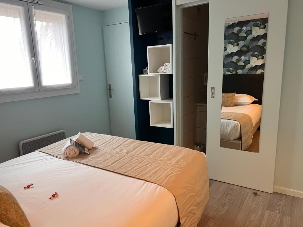 Ein Schlafzimmer mit einem Bett, einem Kleiderschrank und einem Spiegel, der ein Bett wiederspiegelt.