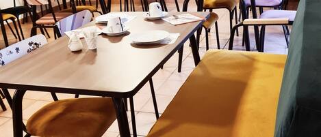 Un espace repas comprenant plusieurs tables et chaises, dont certaines sont dotées de coussins.