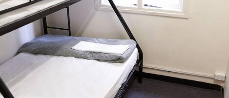 A bunk bed room with a window and curtains.