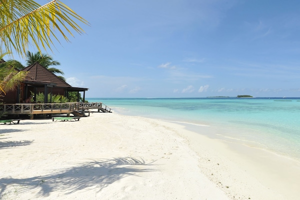 Perto da praia, areia branca, toalhas de praia, prática de windsurfe