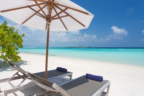 Beach nearby, white sand, beach towels, windsurfing