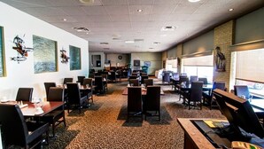 A conference room with multiple tables and chairs, equipped with computers and presentation screens. - Wescana Inn (The Pas)