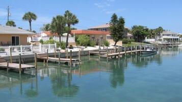 A waterfront property with a dock, clear water, and residential buildings.