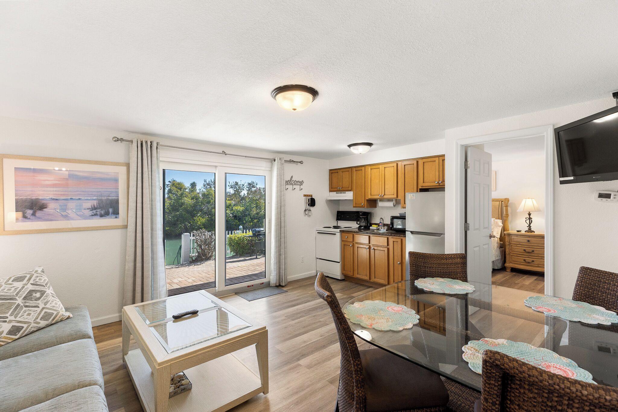 Un appartement moderne comprenant un coin repas, une cuisine et une grande porte-fenêtre coulissante donnant sur l’extérieur.
