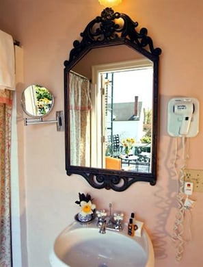 Une salle de bain avec un grand miroir, un lavabo et un téléphone.