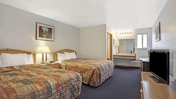 A hotel room with two beds, a television, a desk with a lamp, a mirror, and a painting on the wall.