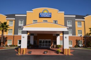 Ein Days Inn & Suites Gebäude mit modernem Design, das eine markante Eingangspartie und einen klaren Himmel zeigt.