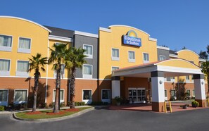 Un hôtel Day's Inn & Suites à la façade jaune, doté de nombreuses fenêtres et d'une entrée abritée.