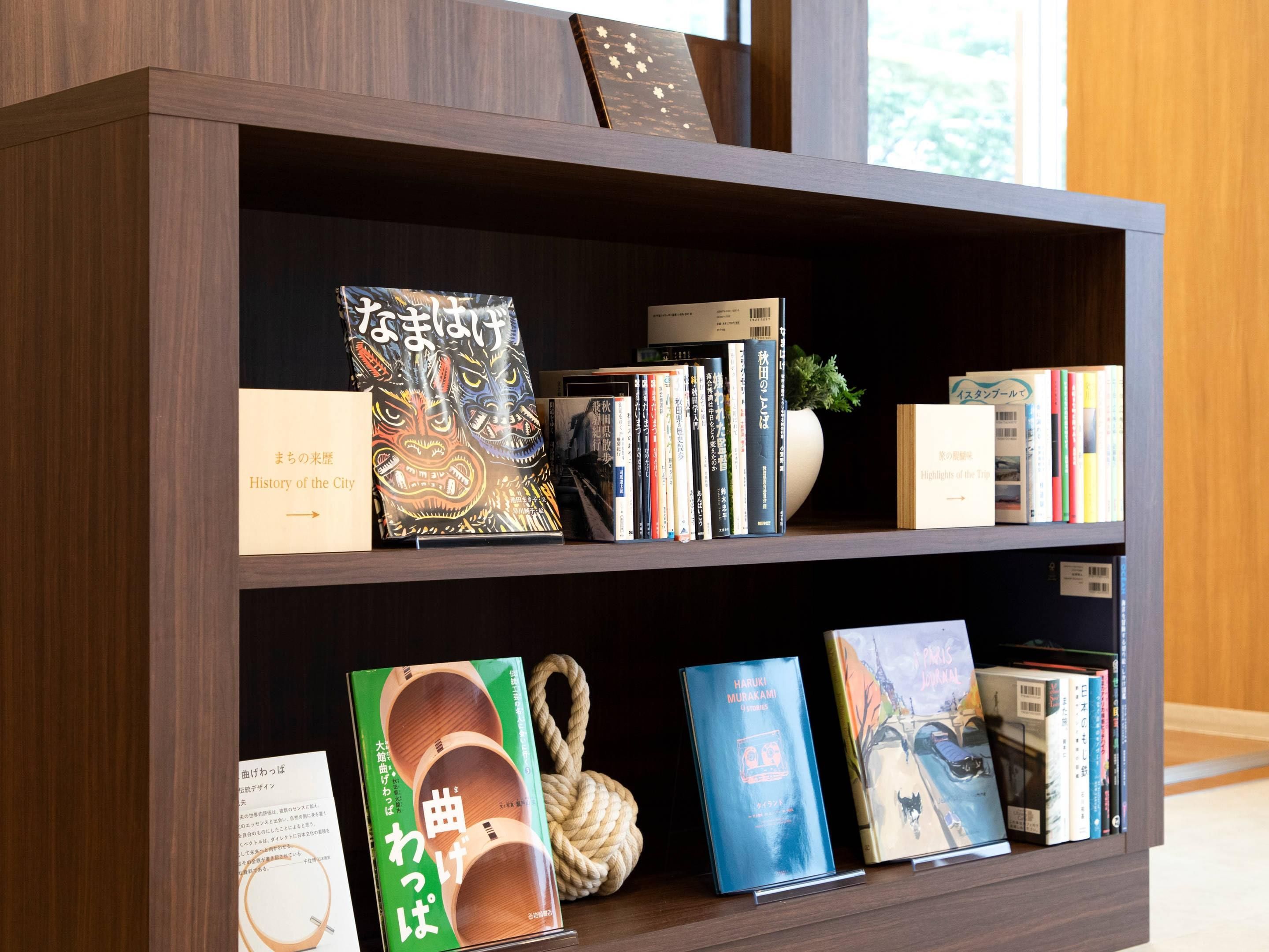 A bookshelf with various books and a decorative rope.