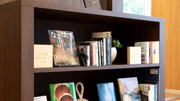 A bookshelf with various books and a decorative rope.