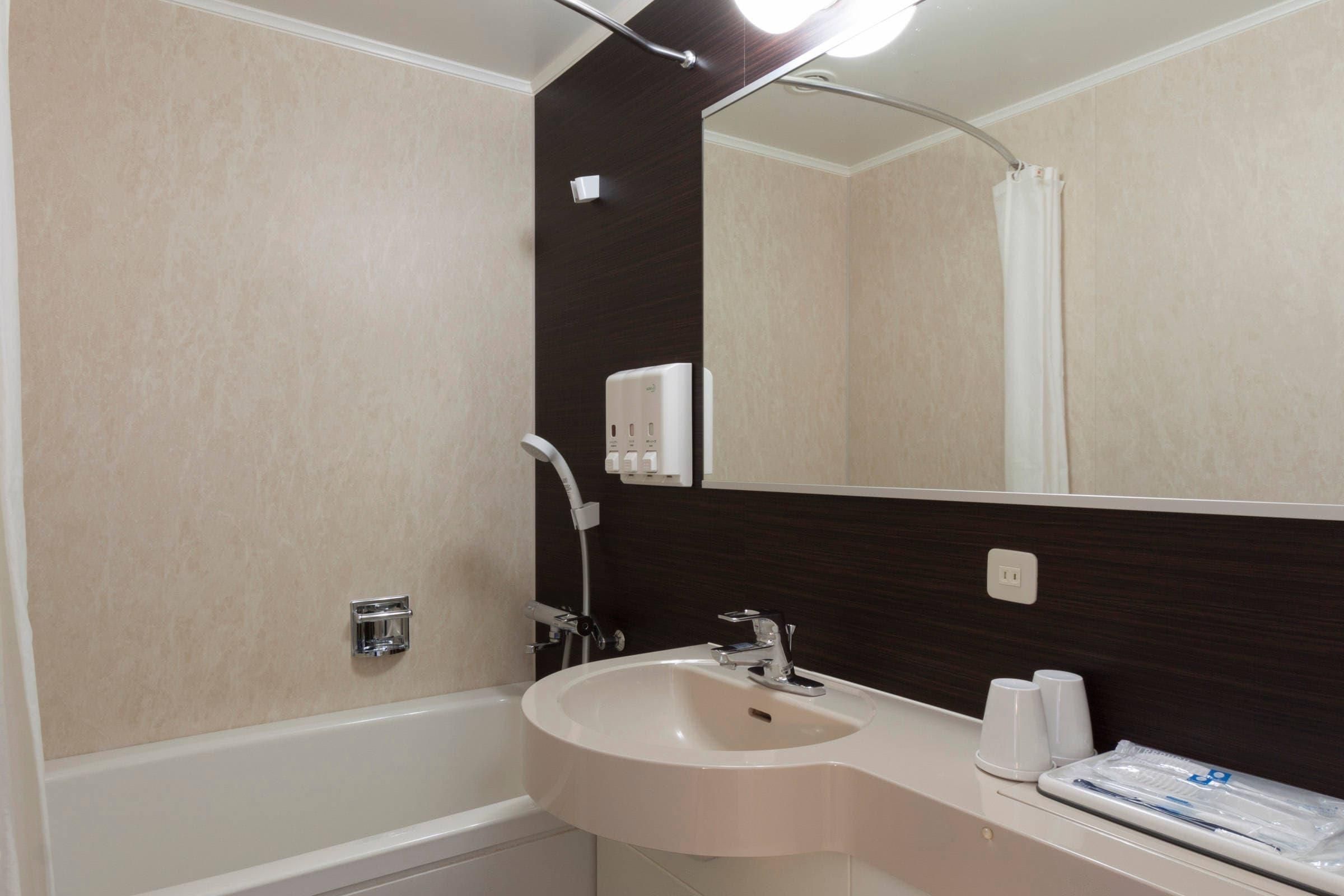 Ein Badezimmer mit Badewanne, Waschbecken, Spiegel und Handtuchhalter.