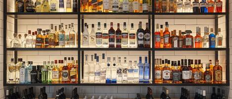 A bar with multiple shelves of liquor bottles and glasses.