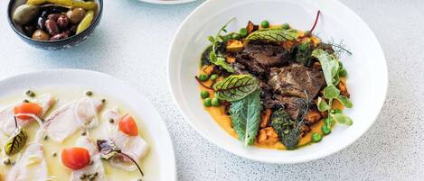 A variety of dishes including a bowl of soup, a plate with meat and greens, and a bowl of rice.