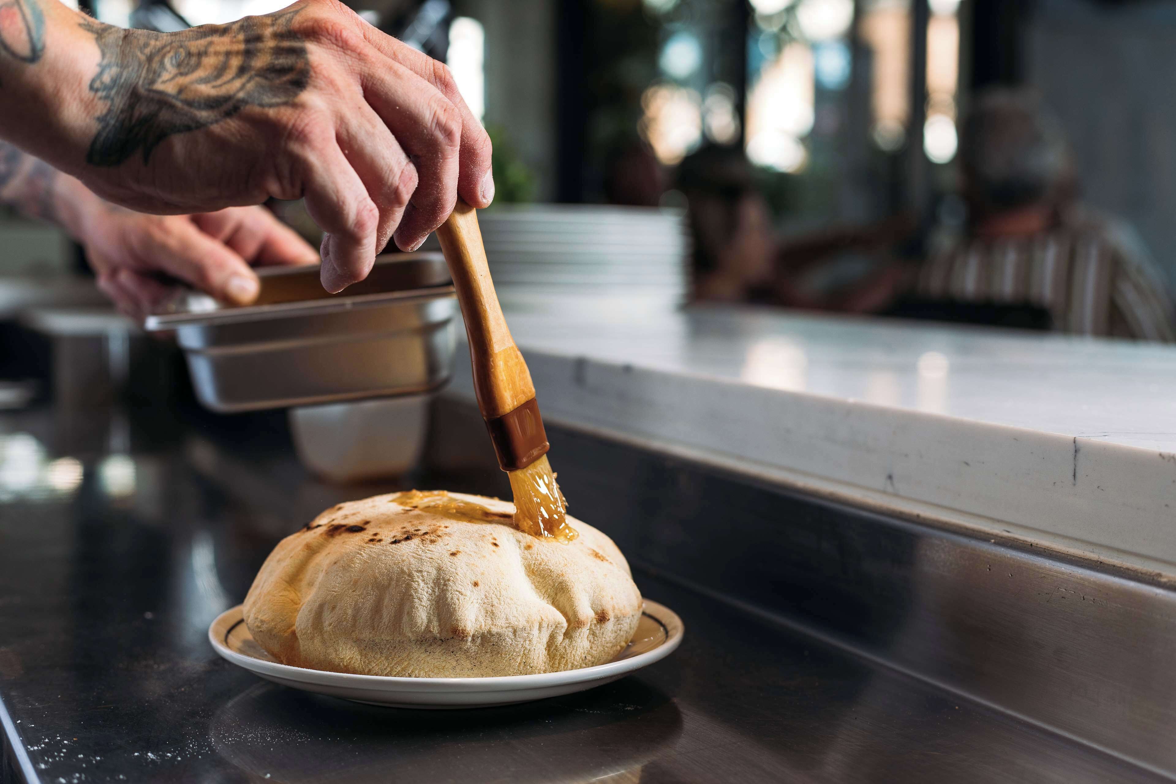A person pouring honey onto a dessert.