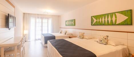 Ein Hotelzimmer mit zwei Betten, einem Schreibtisch und einem Fernseher.