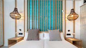 Una habitación de hotel moderna con una cama grande, dos mesitas de noche y un panel decorativo en la pared.
