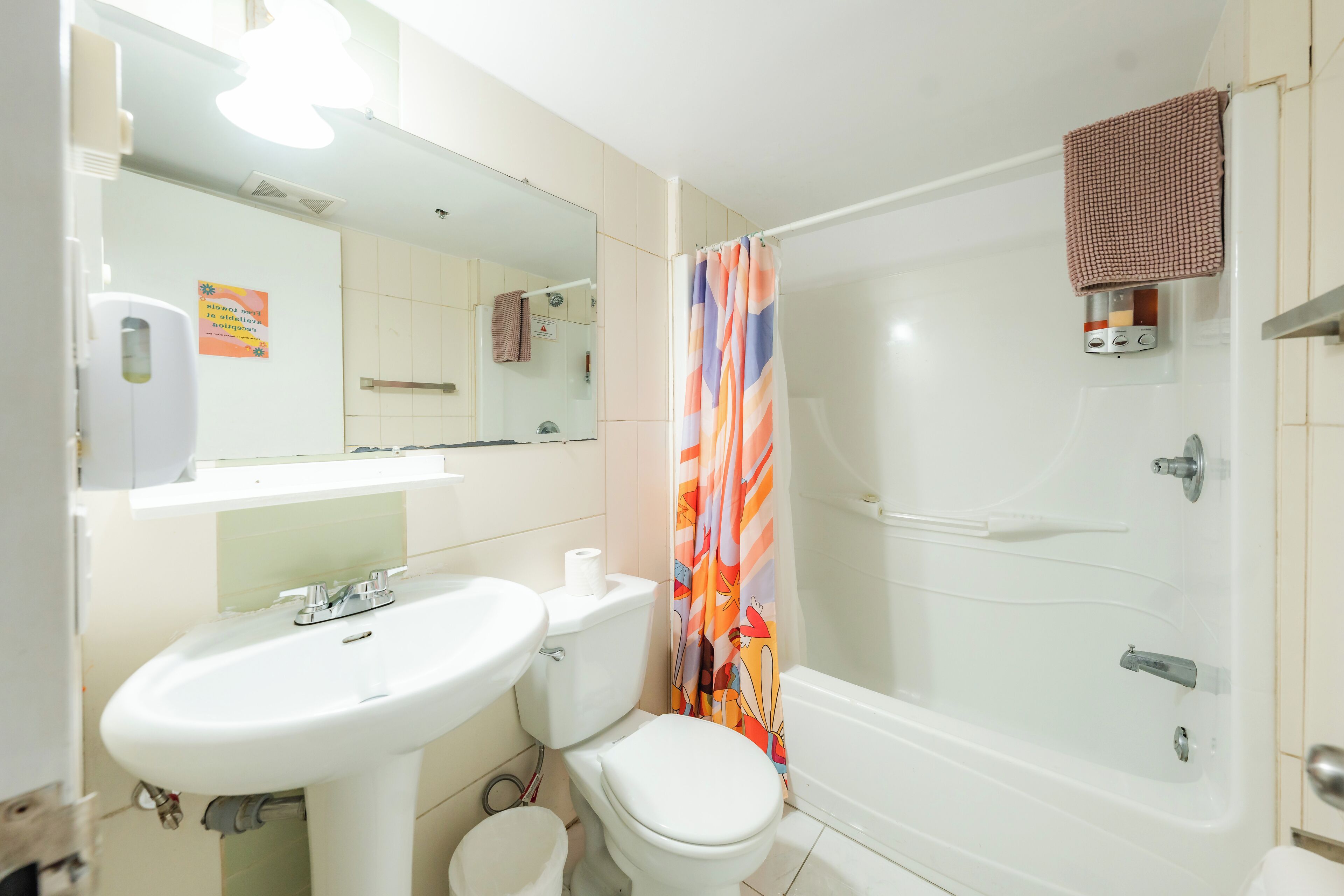 Un baño con lavamanos, inodoro y ducha.
