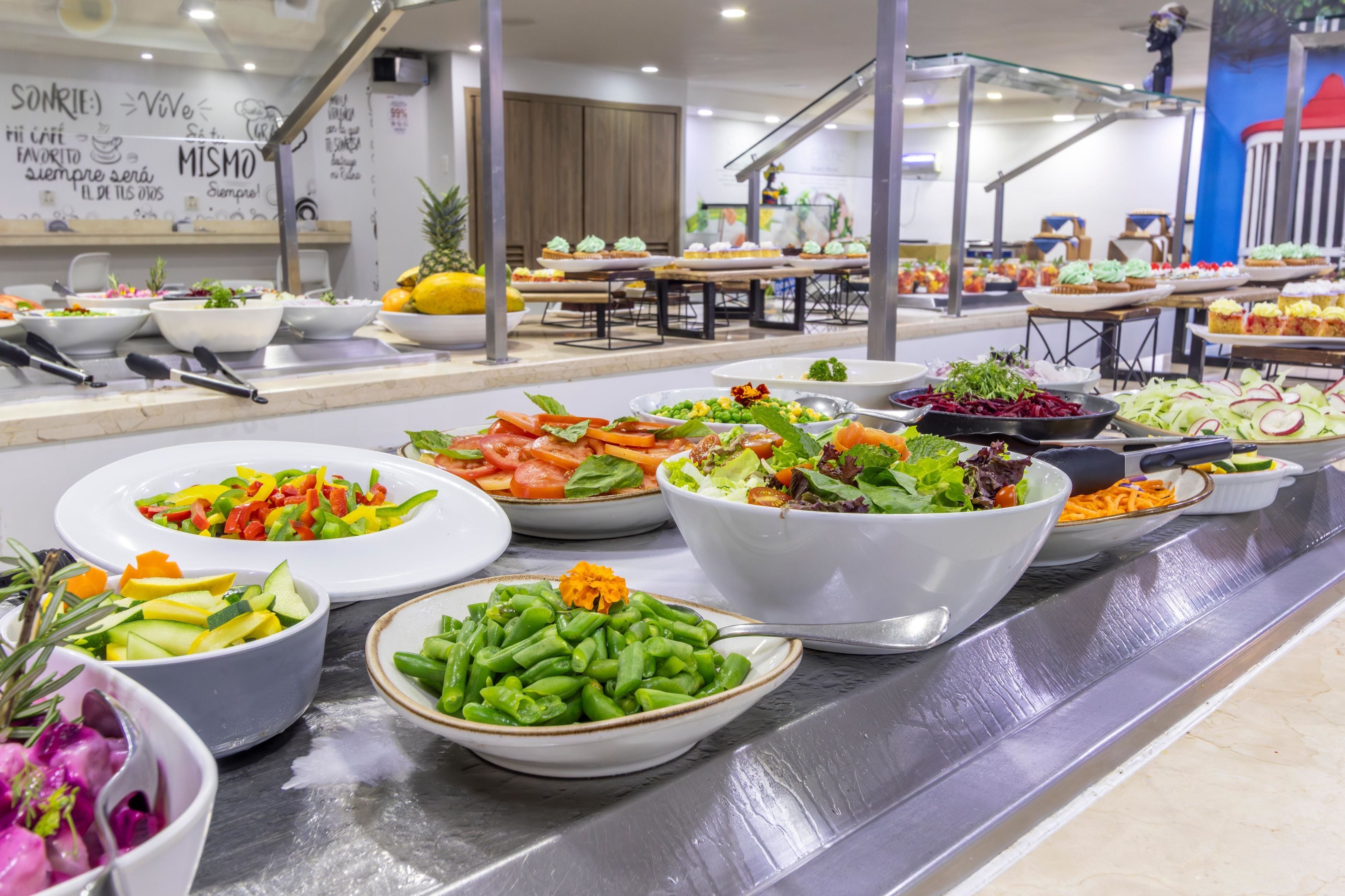 Un bufé con ensaladas y frutas variadas.