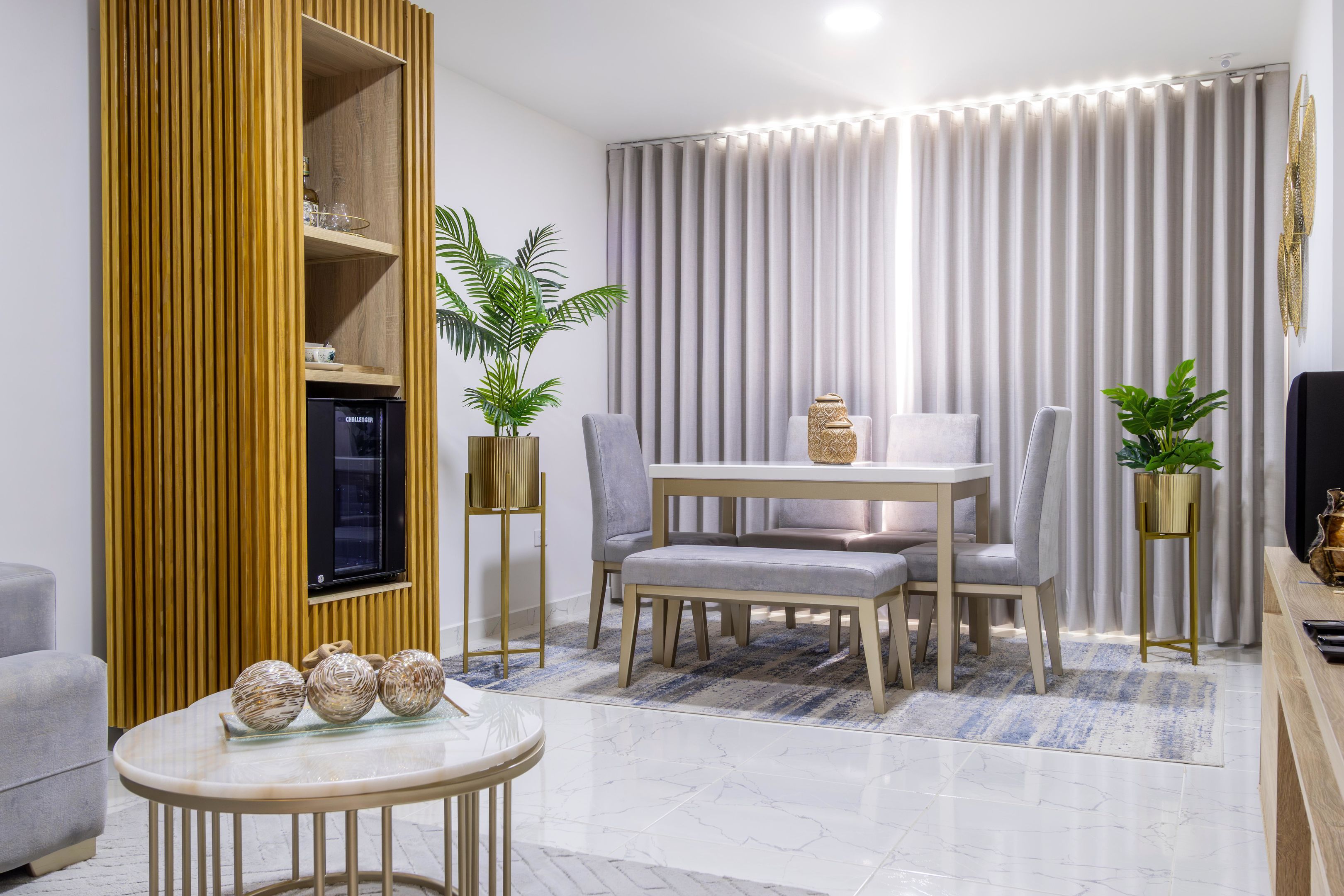 Un salon moderne avec un téléviseur, des sièges et une plante.