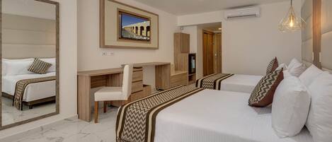 A hotel room with a large bed, a desk, a chair, a mirror, and a television.