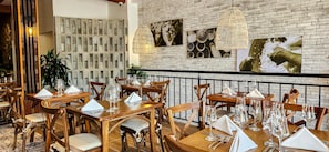 A restaurant interior with brick walls, wooden tables, and chairs.