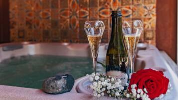 Un jacuzzi con champán y una rosa roja.