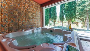 A hot tub with a tiled wall and a view of trees. - La Villa Vicha, The Originals Relais (Aubais)