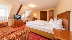 Une chambre d’hôtel avec un grand lit, une télévision, un bureau et une chaise.