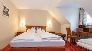 Una habitación de hotel con una cama grande, dos mesitas de noche, un escritorio y una silla.