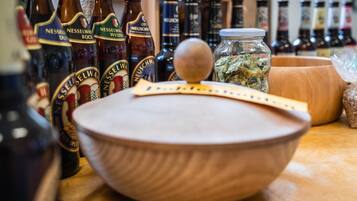 Un cuenco de madera con tapa sobre una mesa, rodeado de botellas de cerveza Nesselman.