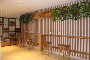 A reception area with a wooden counter, bar stools, and a sign that reads "DORADO PLAZA." - Hotel Dorado Plaza Bocagrande - All Inclusive (Cartagena)