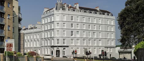 A large, historic building with multiple floors and a prominent tower.