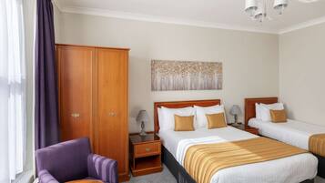 A hotel room with two beds, a wardrobe, a chair, a nightstand, and a painting on the wall.