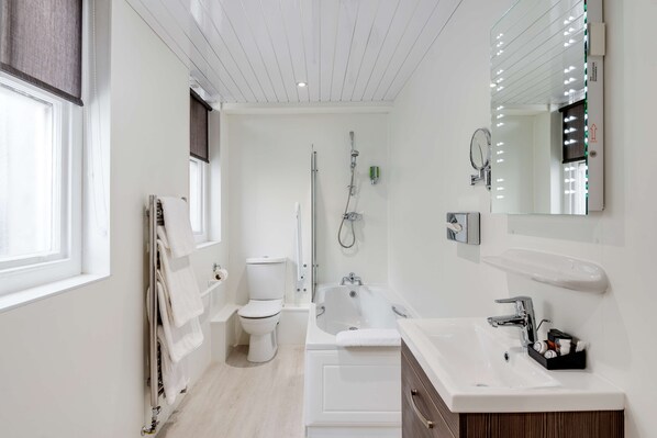 Un baño moderno con inodoro, bañera y lavamanos.