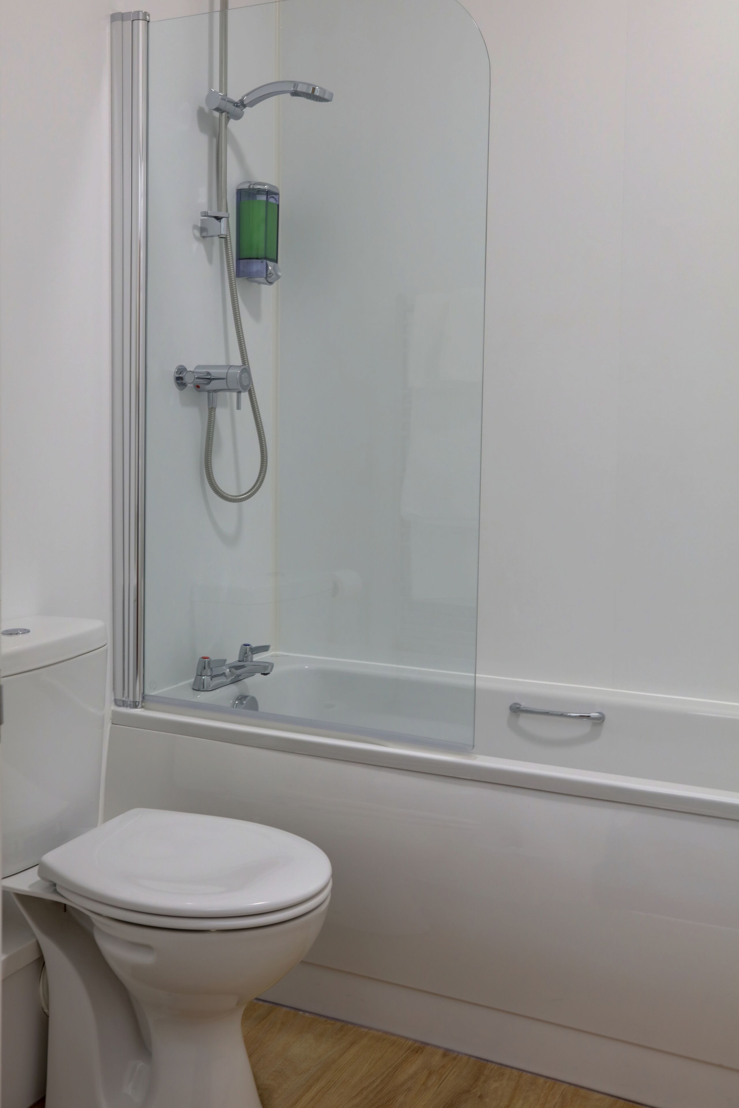 Un baño con ducha envuelta en vidrio, inodoro y bañera.