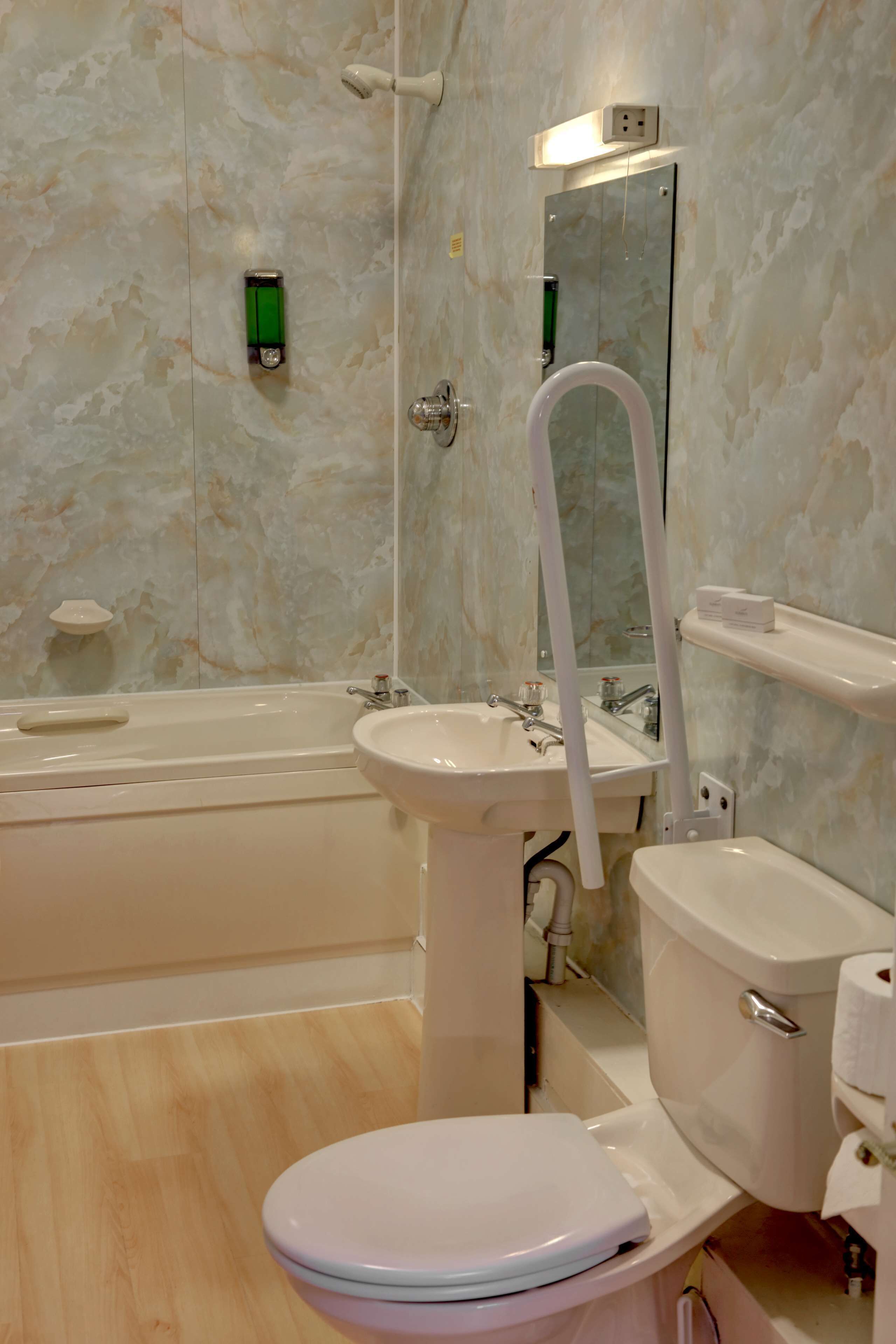 A bathroom with a bathtub, sink, toilet, and a mirror.